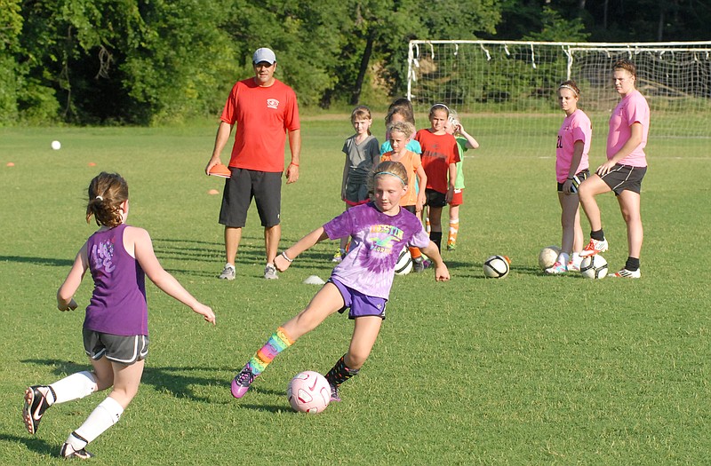 Jefferson City High School soccer coach Eddie Horn looks on as Piper Jaques and Layne Fatherley work on a drill during Lady Jays soccer camp this week at the 179 Soccer Park.