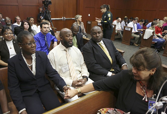 State Attorney Angela Corey, right foreground, reaches to comfort Sybrina Fulton, Trayvon Martin's mother, before Fulton takes the stand during George Zimmerman's trial in Seminole County circuit court July 5 in Sanford, Fla. Trayvon's father, Tracy Martin, center, and family attorney Daryl Parks, far right, sit beside her. 