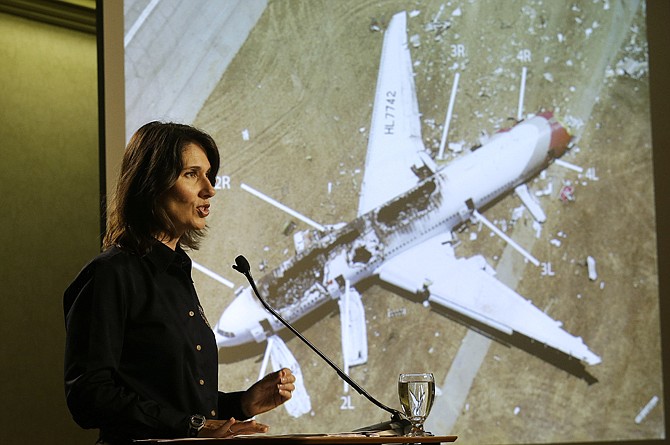 Deborah Hersman of the National Transportation Safety Board speaks Thursday in front of a photograph of Asiana Flight 214, which crashed on Saturday at San Francisco International Airport.