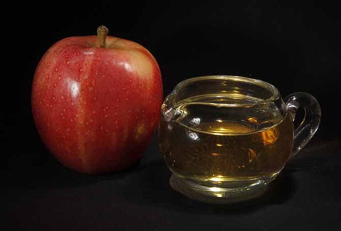 In this Sept. 15, 2011 photo, an apple and a pitcher of apple juice are posed together in Moreland Hills, Ohio. The Food and Drug Administration is setting a new limit on the level of arsenic allowed in apple juice, after more than a year of public pressure from consumer groups worried about the contaminant's effects on children. 