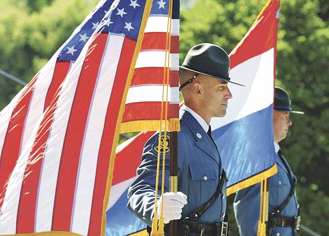 Cpl. Bruce McLaughlin, near, and Sgt. Jason Cluver of the Troop F Color Guard, stand with their respective flags during the commencement ceremony for the 96th Recruit Class of the Missouri State Highway Patrol on Friday in Jefferson City.