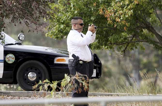 A sheriff's investigator takes photographs during the search for possible human remains found at the home of 11-year-old Terry Dewayne Smith Jr., who vanished over the weekend, in rural Menifee, Calif. Wednesday, July 10, 2013. (AP Photo/The Press-Enterprise, Frank Bellino)