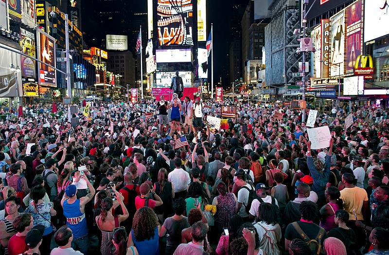 Throngs of marchers gather on Times Square as they listen to a speaker Sunday in New York, for a protest against the acquittal of volunteer neighborhood watch member George Zimmerman in the 2012 killing of 17-year-old Trayvon Martin.