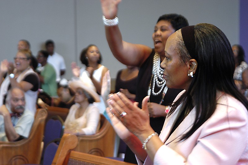 Some members of Quinn Chapel A.M.E. sway and clap their hands to music during Sunday's dedication of the church's new building, less than a block away from the old location.                                