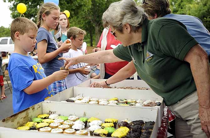 Volunteer Claudia Arnold hands Peyton Leonard, of Detroit Lakes, Minn., a cupcake to enjoy during Runge Nature Center's 20th birthday celebration on Saturday in Jefferson City.