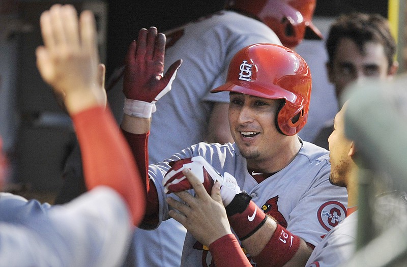 Allen Craig of the Cardinals celebrates in the dugout after scoring a run in the fourth inning of Sunday's game with the Cubs in Chicago.