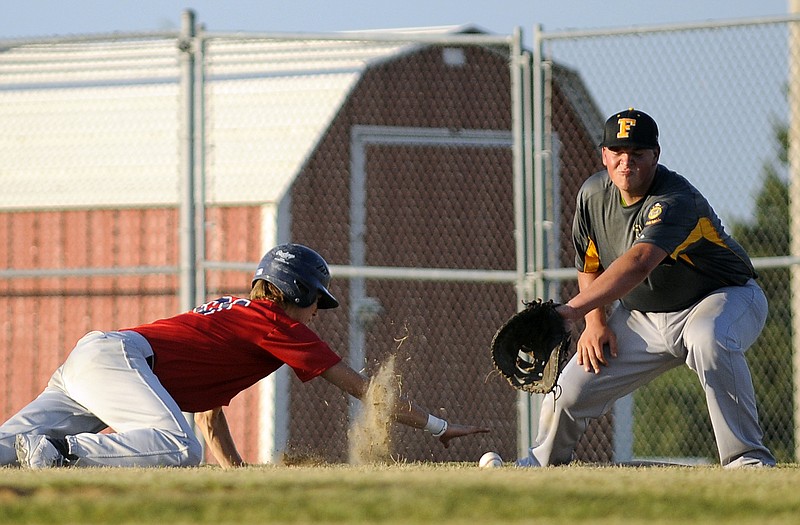 Logan Bax of the Jefferson City American Legion Post 5 Seniors dives back to first on a pickoff attempt during Wednesday night's district tournament game with Fulton at the American Legion Sports Complex.