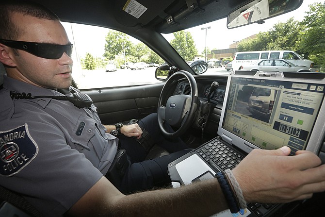 Officer Dennis Vafier, of the Alexandria Police Department, uses a laptop in his squad car to scan vehicle license plates during his patrols in Alexandria, Va. Local police departments across the country have amassed millions of digital records on the location and movements of vehicles with a license plate using automated scanners.
