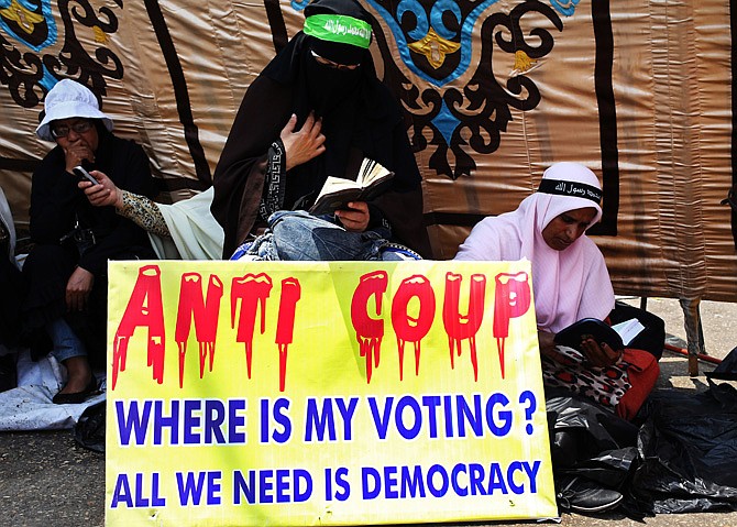 Supporters of Egypt's ousted President Mohammed Morsi read Islam's holy book, the Quran, during the Friday prayer where protesters have installed their camp and hold their daily rally, at Nasr City, Cairo, Egypt.