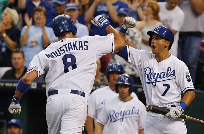 Kansas City Royals' David Lough (7) congratulates teammate Mike Moustakas (8) after his solo home run off Detroit Tigers starting pitcher Justin Verlander during the fifth inning of a baseball game at Kauffman Stadium in Kansas City, Mo., Saturday, July 20, 2013.