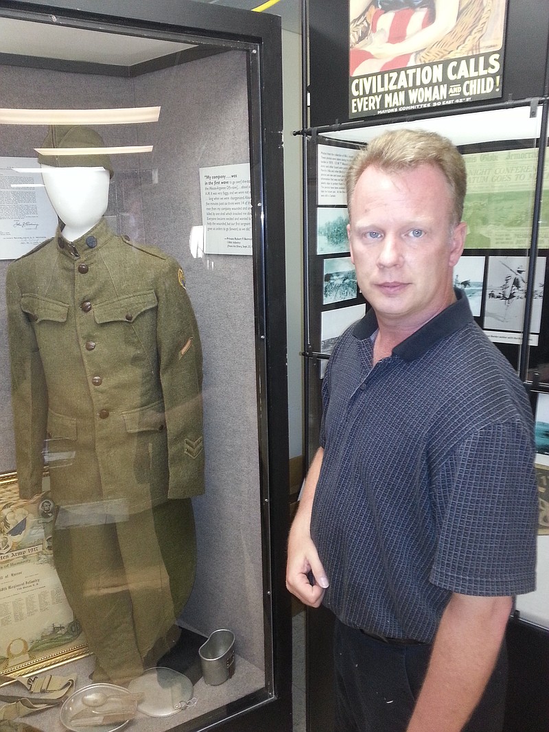 Charles Machon, director of the Museum of Missouri Military History, stands next to a display containing a uniform worn by a Missouri soldier during World War I.     