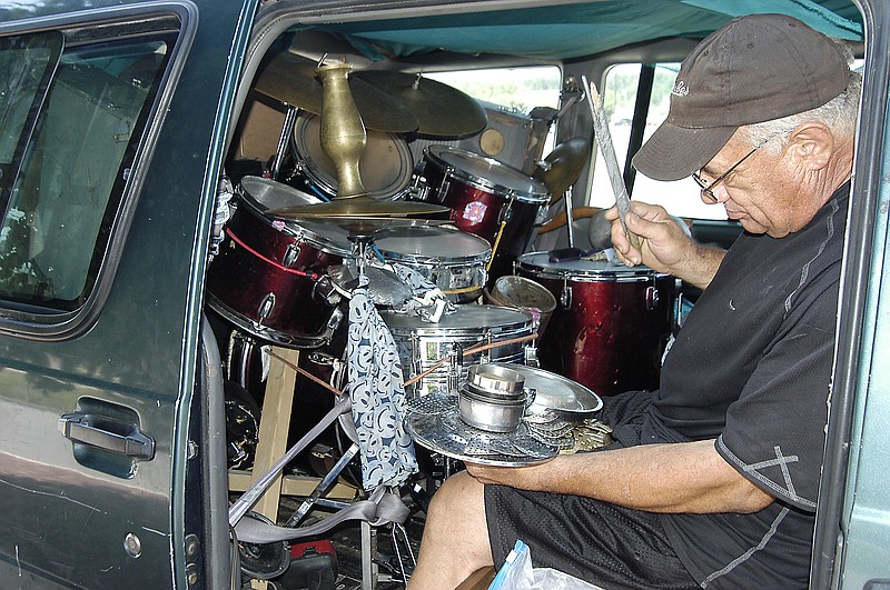 With a well-worn drum stick in one hand, Jay Parks holds a percussion instrument that he crafted himself and calls a "flower." Parks plays drums in his van for hours a day (and night) at Walmart and other local parking lots.              
