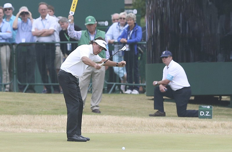 Phil Mickelson watches as his birdie putt on the 18th green inches toward the hole during Sunday's final round of the British Open.