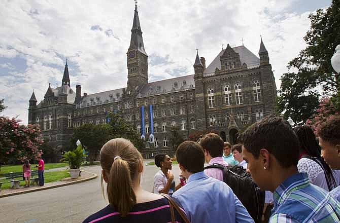 Prospective students tour Georgetown University's campus in Washington, in this Wednesday, July 10, 2013, file photo. Grants and scholarships are taking a leading role in paying college bills, surpassing the traditional role parents long have played in helping foot the bills, according to a report from loan giant Sallie Mae. 