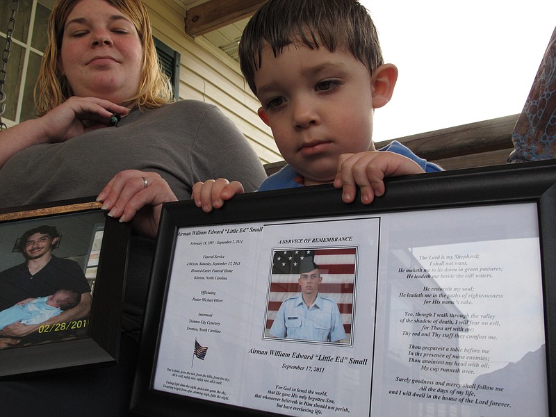 Shane Mercer points to a photo of his father, Airman Will Small, March 18 as his mother Alecia Mercer looks on at their home in Kinston, N.C. Small, whose organs were donated to four patients after he died, had at least two untreated raccoon bites several months before he became sick, and tests confirm his rabies-infected kidney led to a recipient's death, according to a report published Tuesday in the Journal of the American Medical Association.