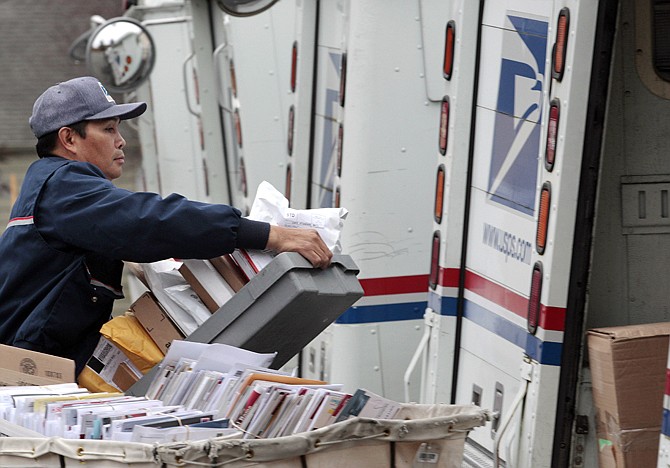 Diosdado Gabnat moves boxes of mail into his truck to begin delivery at a post office in Seattle in December 2011. 