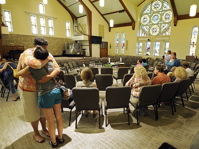 Katie Gordon, left, and Amanda Gingrich share an emotional embrace as they and others gather at First United Methodist Church for a prayer vigil Wednesday to support the family of Chad Rogers, a former youth minister at the church who is missing.