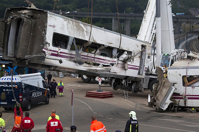 Derailed cars are removed as emergency personnel work at the site of a train accident in Santiago de Compostela, Spain on Thursday. 