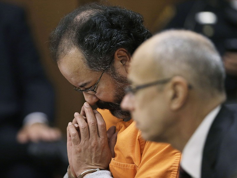 Ariel Castro looks down Friday during court proceedings in Cleveland. Castro, who imprisoned three women in his home, subjecting them to a decade of rapes and beatings, pleaded guilty Friday to 937 counts in a deal to avoid the death penalty. Defense attorney Jaye Schlachet is on the right.