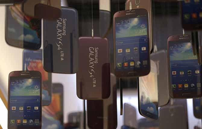 Models of Samsung Electronics' Galaxy S4 smart phones are displayed at a showroom of its headquarters in Seoul, South Korea, Friday, July 26, 2013.