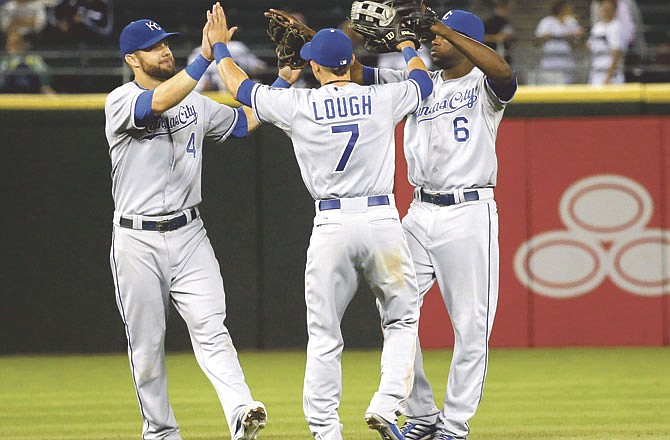 Kansas City Royals right fielder David Lough (7), Alex Gordon, left, and Lorenzo Cain celebrate a 5-1 win over the Chicago White Sox after a baseball game on Friday, July 26, 2013, in Chicago.
