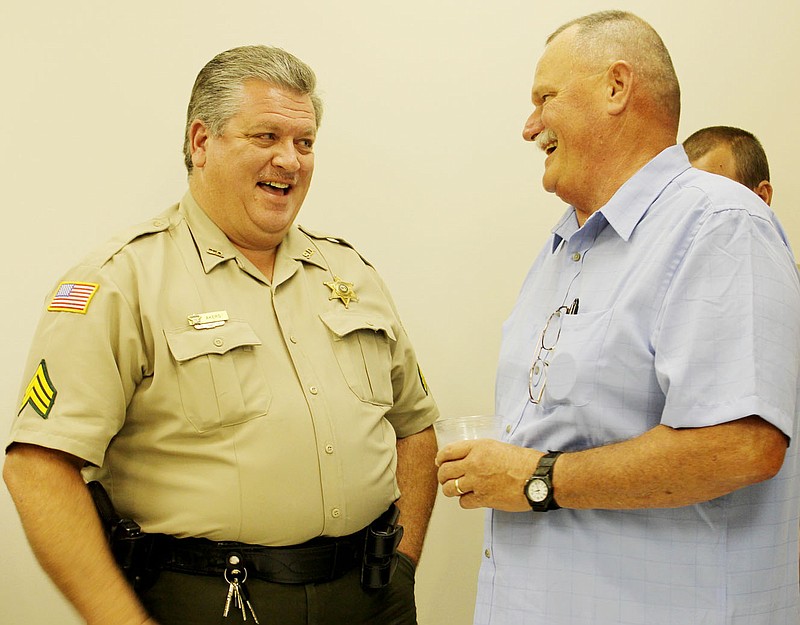 Lt. Tim Osburn, right, chief investigator for the Callaway County Sheriff's Office, is congratulated Friday by Sgt. Bill Akers of the Callaway County Sheriff's Office on Osburn's announcement he plans to retire on July 31. A reception for Osburn was held Friday afternoon at the Callaway County Emergency Operations Center.