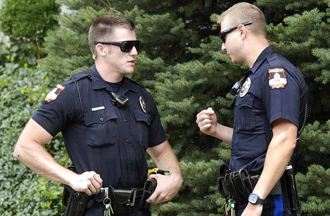 JCPD officers Collier Nichols, right, and Nick Sanders discuss an incident after responding to a residential call. The department is short staffed and logging about 1,000 overtime hours per month as a result.