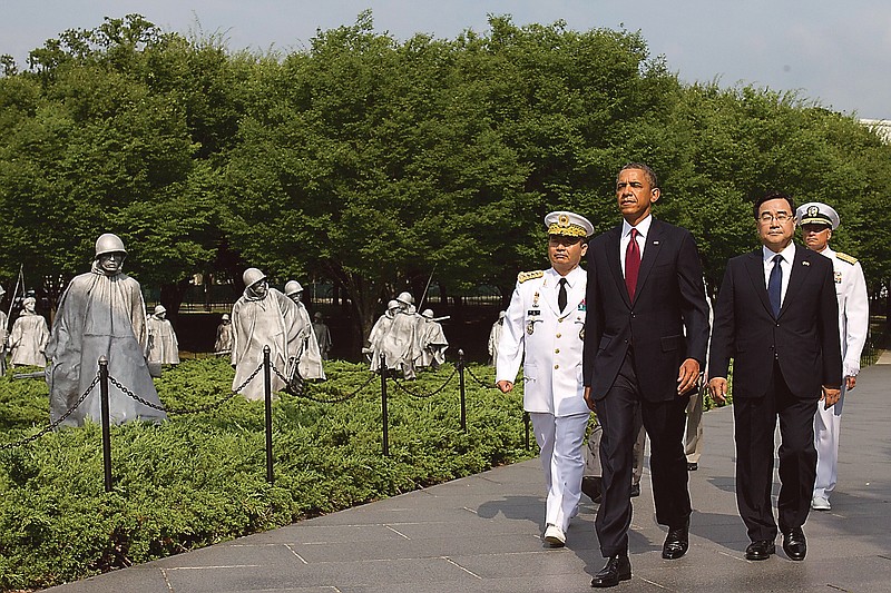 President Barack Obama, center, walks with Korea's Chairman of the Joint Chiefs of Staff Gen. Jung, left, and Special Envoy from the Republic of Korea Kim Jung Hun, during a commemorative ceremony at the Korean War Veterans Memorial on the 60th anniversary of the end of the Korean War.