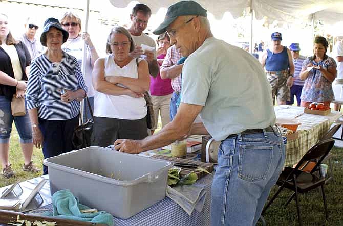 Dan Kuebler a local produce grower with "The Salad Garden" from Ashland, Mo., demostrates how to make sauerkraut at the "Taste of Local Missouri" event held at the city park in Linn on Saturday. Kuebler has been in the produce growing business for sveral decades and often sells his produce at the Columbia Farmers market but is hoping to participate in the Lincoln University Farmers Market soon.