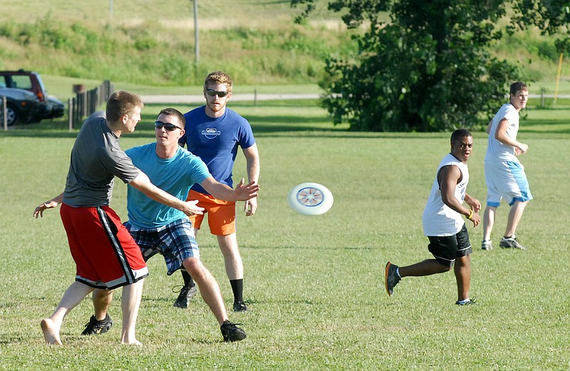 Sean Hogan looks for an open teammate while Tim Wright attempts to block the throw during a game of Ultimate Frisbee down at the North Jefferson City Recreation Area field. 
