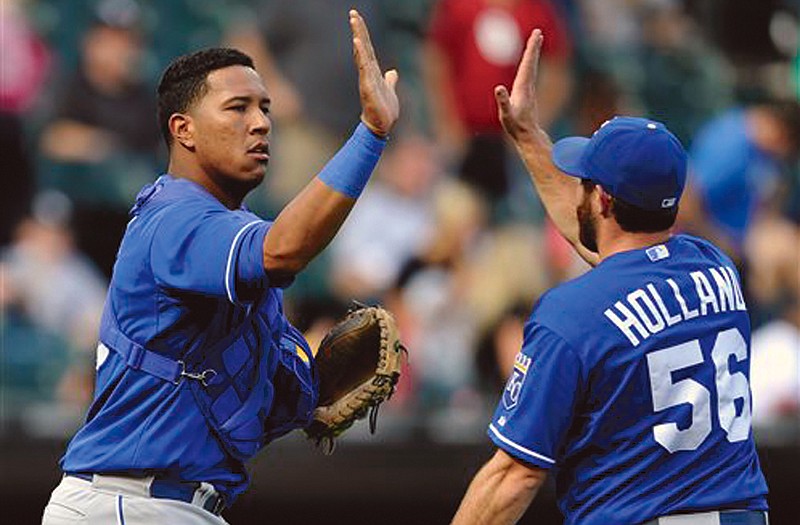 The Royals' Salvador Perez and Greg Holland (56) celebrate after defeating the White Sox 4-2 on Sunday in Chicago.