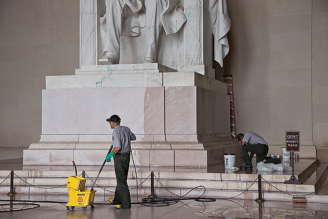 National Park Service workers clean the Lincoln Memorial in Washington after someone splattered green paint on the statue of the 16th president and the floor area. Similar green paint was used to deface chapels in the National Cathedral and a statue at the Smithsonian.