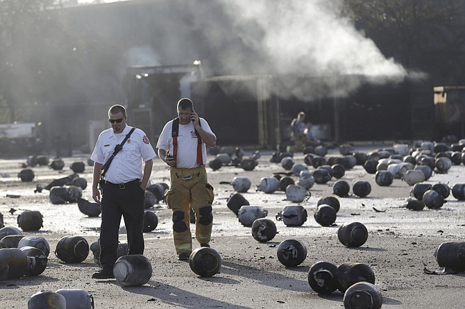Firefighters walk Tuesday through an area of exploded propane cylinders in the aftermath of an explosion and fire at a propane gas company in Tavares, Fla. Eight people were injured, with at least three in critical condition. John Herrell of the Lake County Sheriff's Office said early Tuesday there were no fatalities despite massive blasts that ripped through the Blue Rhino propane plant late Monday night.