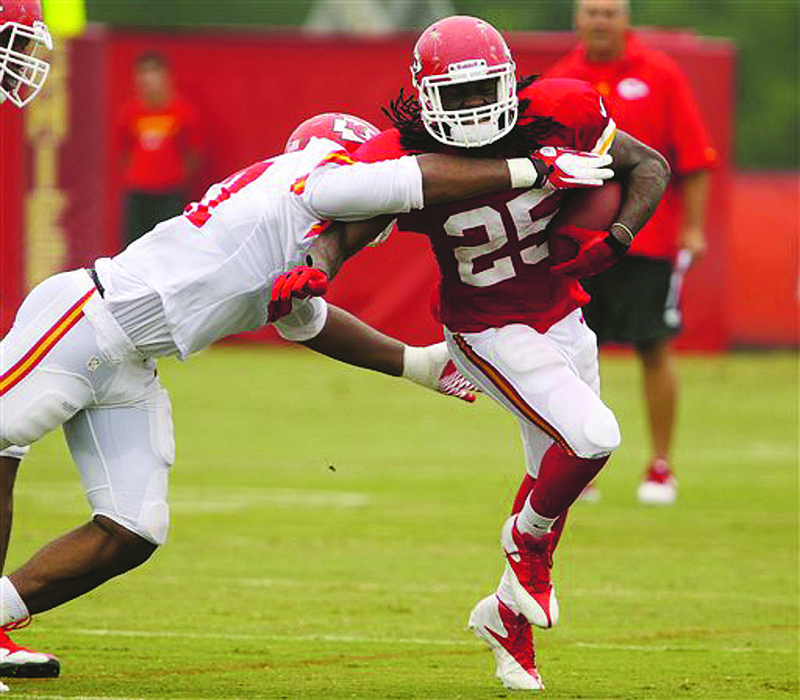 Chiefs linebacker Nico Johnson tries to bring down running back Jamaal Charles during training camp Tuesday in St. Joseph.