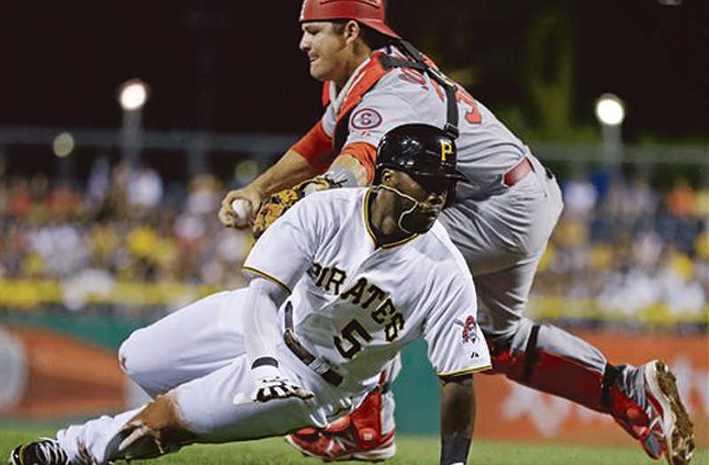 The Pirates' Josh Harrison avoids the tag of Cardinals catcher Rob Johnson during a rundown between third and home during the second game of Tuesday's doubleheader in Pittsburgh.