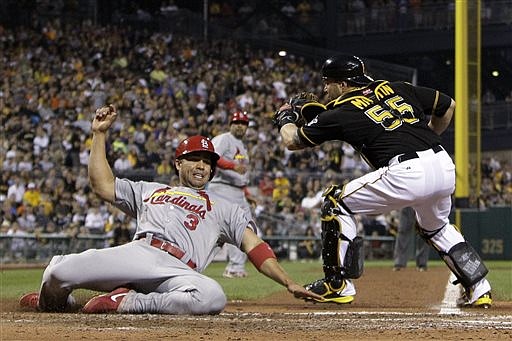 Carlos Beltran of the Cardinals slides home safely ahead of the attempted tag of Pirates catcher Russell Martin during the fourth inning of Wednesday night's game in Pittsburgh.