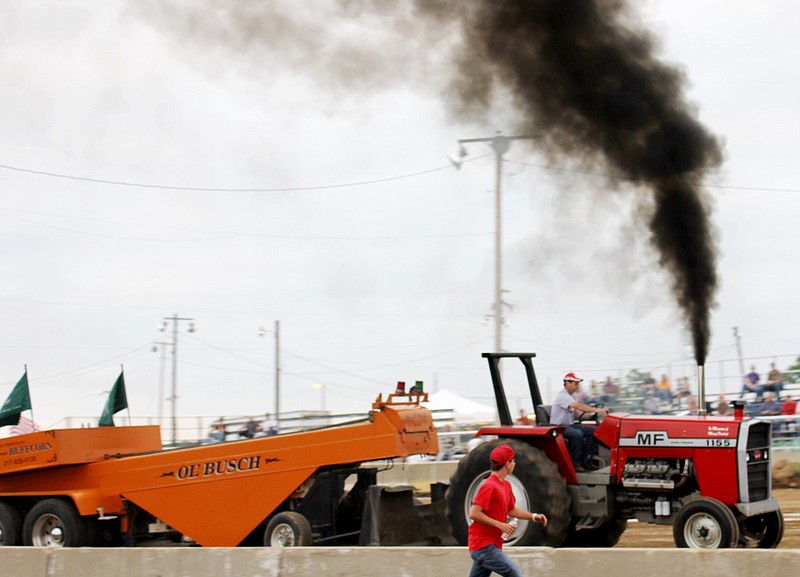 Black diesel smoke shoots up from a Massey Ferguson 1155 tractor driven by Darrell Dunlap of Fulton Wednesday night at the Callaway County Fair. Dunlap competed in the 12,500-pound class of Missouri Tractor Pullers competition. His 294 feet, 10-inch effort captured fourth place in his class.
