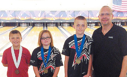 Proudly wearing the medals they earned at the Show-Me Bowling Games July 20-21 at Columbia, and representing California Lanes, from left, are Andrew Barber, Zoey Rimel and Caleb Weis with their coach, Mike Heinaman.