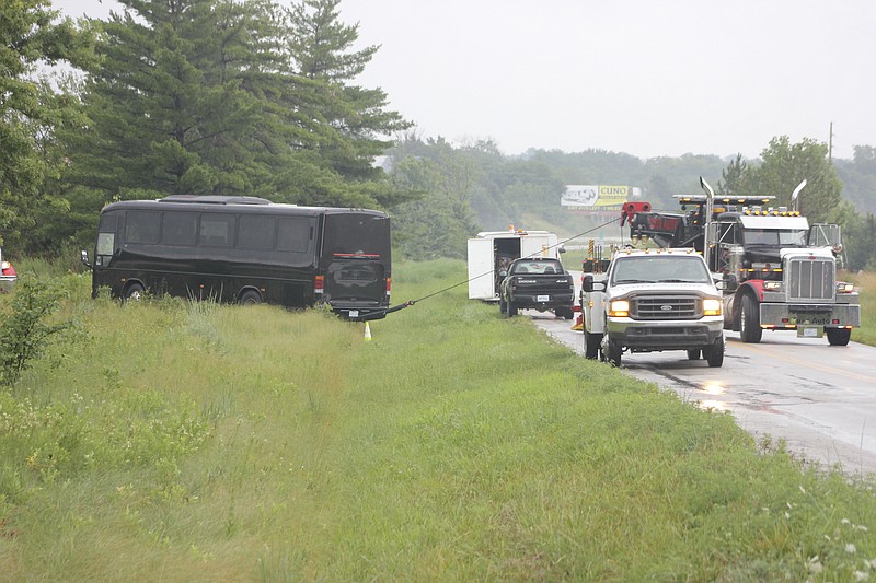 A tow truck pulls a charter bus from a ditch near Danville, about 20 miles east of Kingdom City, Friday afternoon. While driving on a ramp for I-70 eastbound the bus went off the road and tipped onto its side. Bus passengers included students from the Missouri School for the Deaf in Fulton.