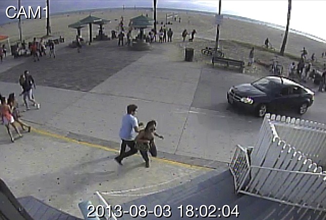 In this image take from a security camera, pedestrians scatter as a car drives through a packed afternoon crowd along the Venice Beach boardwalk in Los Angeles, Saturday, Aug. 3, 2013. At least a dozen people were injured, two of them critically, according to police. 