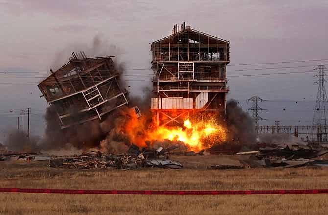 An explosion knocks down one of the remaining towers at the old Kern Power Plant, Saturday, Aug. 3, 2013 in Bakersfield, Calif.