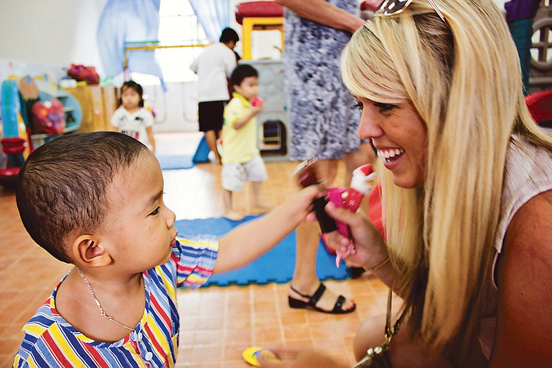 Fulton kindergarten teacher Whitney Eastwood interacts with a student at a school in Vietnam. Eastwood visited the country because her father had served there in the military, she took the opportunity to gather  supplies to donate to schools there.
