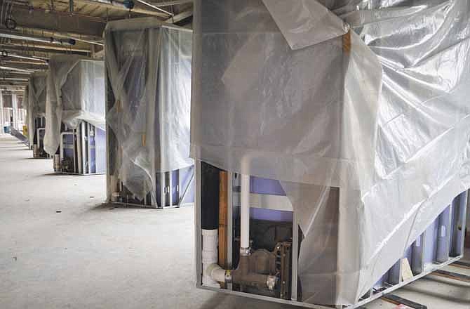 The hospital restrooms are being constructed at an off-site location and moved to the construction site of the new St. Mary's Health Center. They are being built in Jefferson City and transported on a trailer where they are offloaded and lifted onto the floor of the building where they are to be attached to plumbing and electrical. 