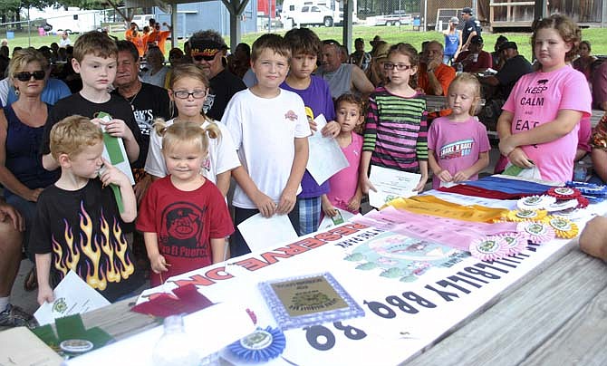 The 2013 Kid's Q ages 5-10 division contestants anxiously await the second and first place winners announcement during the awards ceremony Saturday at the Hillbilly BBQ Cook-off in Laurie, Mo.