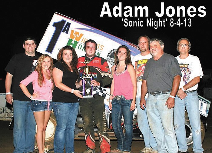 Adam Jones, Wright City, celebrates his 360 Winged Sprint victory with his father Dennis Jones (front right), crew members, and California Sonic girls Sunday night at the Double-X Speedway.
