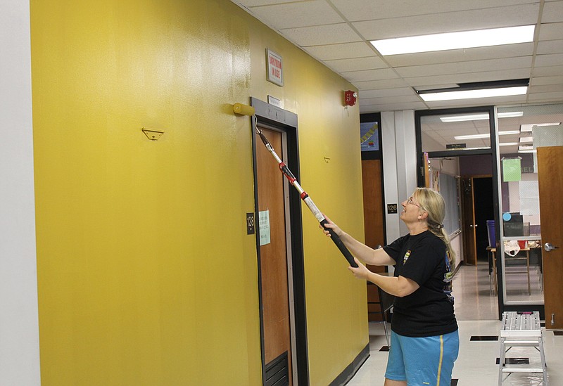Fulton High School math teacher Lyn Dacey paints the hallway outside her classroom gold Wednesday afternoon in preparation of school starting next week. "They're always talking about Hornet Spirit," Dacey said of the decision to redecorate. "I'm going to paint a black chevron pattern on it, so it'll have a little bit of MU Tiger too. It will add a little pizzazz to the hallway." Find more information on going back to school, pick up a copy of the Aug. 8 edition of the Fulton Sun.