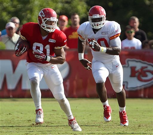 Chiefs linebacker Justin Houston (right) tries to catch tight end Tony Moeaki during training camp Tuesday in St. Joseph.