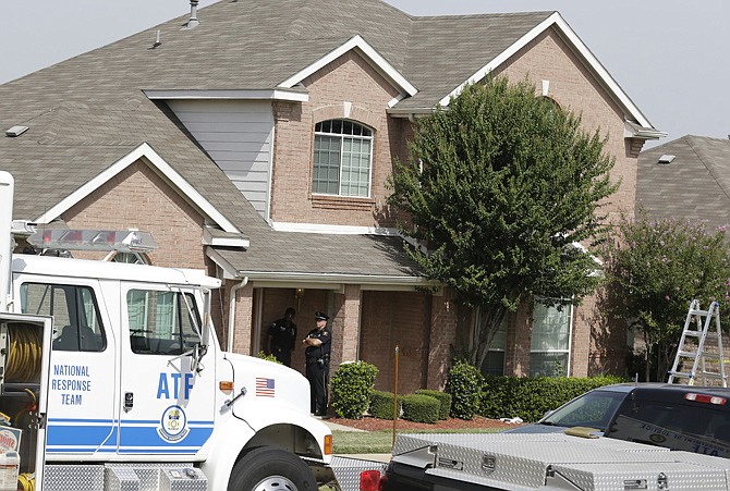 Law enforcement investigators work the house of a fatal shooting Thursday morning in DeSoto, Texas. A man has been arrested in the fatal shooting of four people in two Dallas-area homes, just minutes apart, and police are investigating if he used a grenade or other explosive in one of the attacks. 