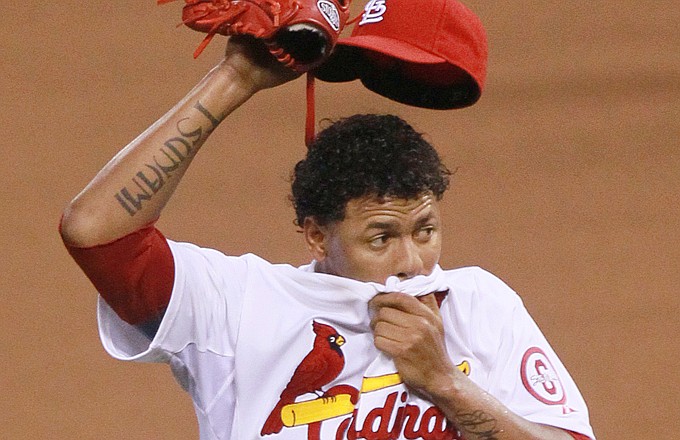 Cardinals starting pitcher Carlos Martinez wipes his face after allowing a walk to A.J. Ellis of the Dodgers in the third inning of Thursday night's game at Busch Stadium.