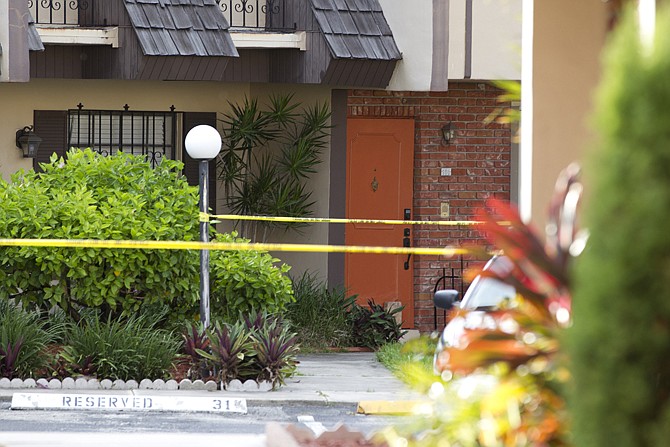 Police tape Thursday blocks the entrance to a murder scene in Miami. Derek Medina, who authorities say fatally shot his wife turned himself in to police on Thursday. 